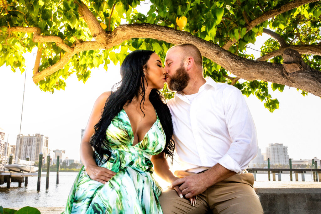 Couple posing under a sea grape tree at sunset during their West Palm Beach engagement photos along the Intracoastal.